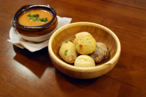 Bread fills a dish sitting next to a bowl of soup.