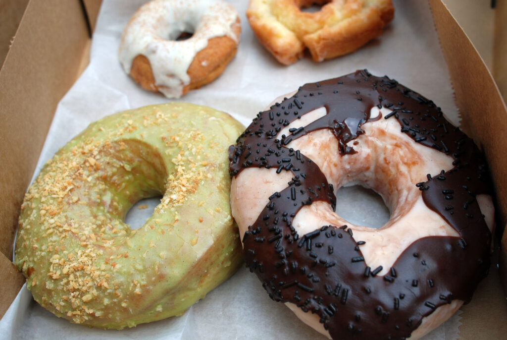 Four different donuts sit next to each other in a box