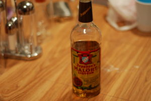 A bottle of Jeppson's Malort sits on a wood surface
