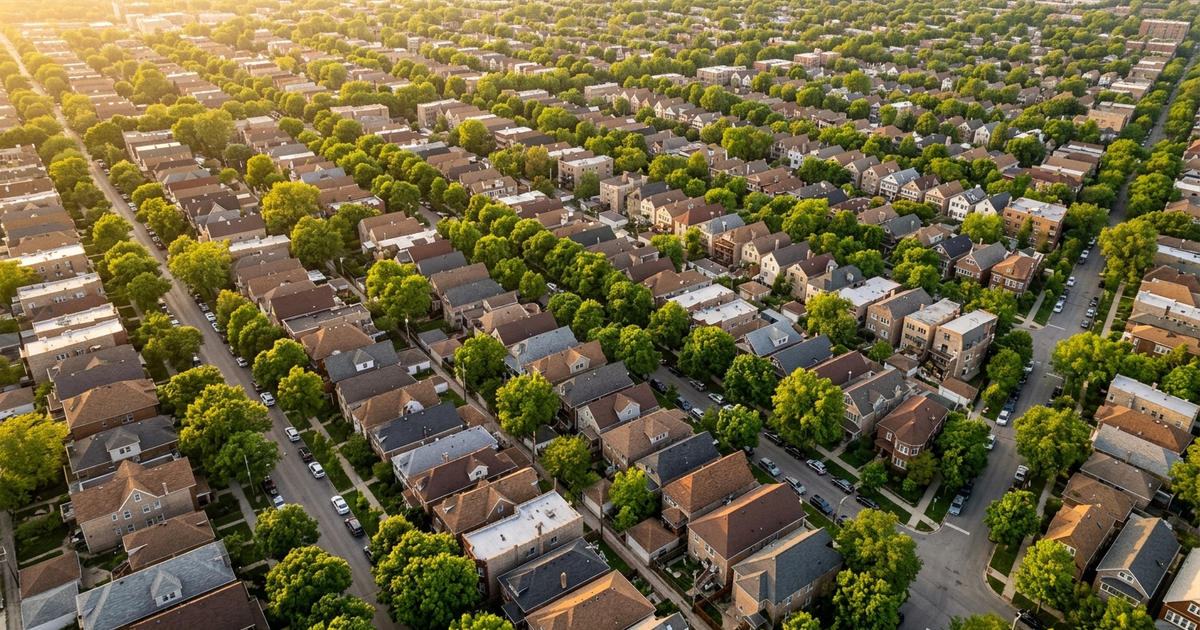 Aerial view of Chicago residential neighborhood with densely packed homes, tree-lined streets, and spring foliage at...