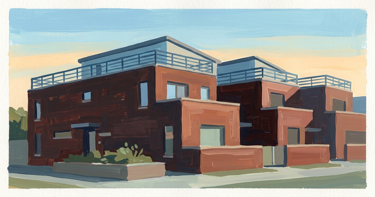Modern red brick residential building with blue railings and stepped architecture under clear sky